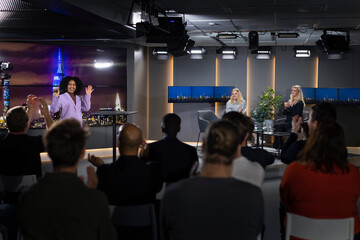 TV show host waving towards audience