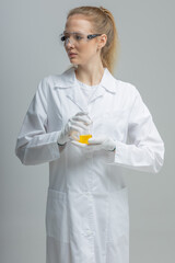 Chemical test tubes and flasks with petroleum products, the girl is a laboratory assistant, safety glasses