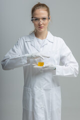 Chemical test tubes and flasks with petroleum products, the girl is a laboratory assistant, safety glasses