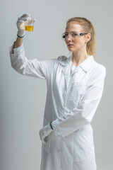 Chemical test tubes and flasks with petroleum products, the girl is a laboratory assistant, safety glasses