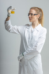 Chemical test tubes and flasks with petroleum products, the girl is a laboratory assistant, safety glasses
