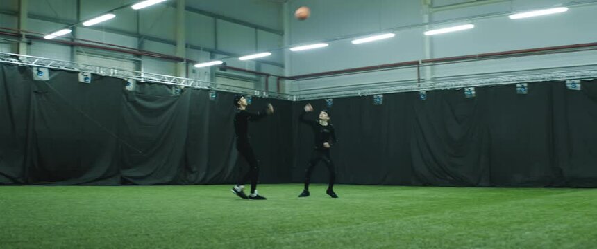 Two professional players in motion capture suits playing basketball as game characters. Motion capture is an unparalleled method for making animated characters move more realistically