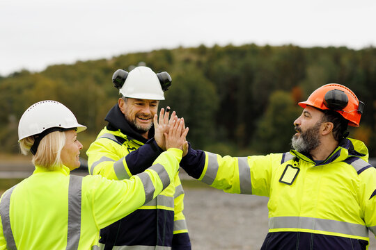 Engineers in reflective clothing high fiving