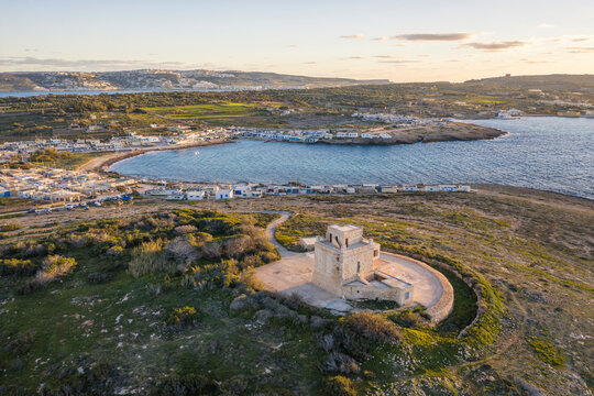 Malta, Northern Region, Mellieha, Aerial view of Ahrax Tower and Armier Bay at dusk