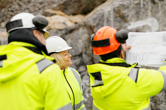 Engineers in reflective clothing discussing plans
