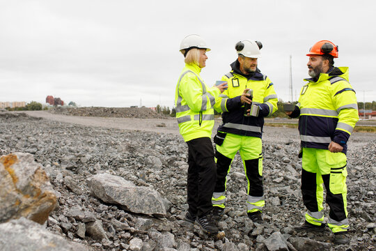 Engineers in reflective clothing having hot drink