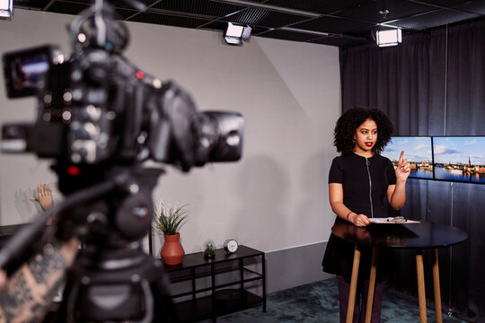 Female news anchor reporting news in studio