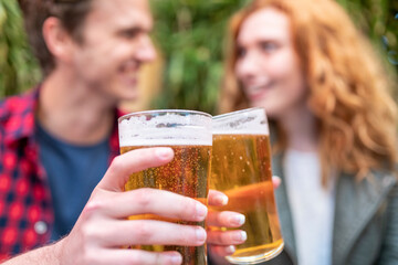 Man and woman toasting beer glasses at pub