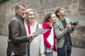 tourists with suitcases and camera walk along the historic streets of European city