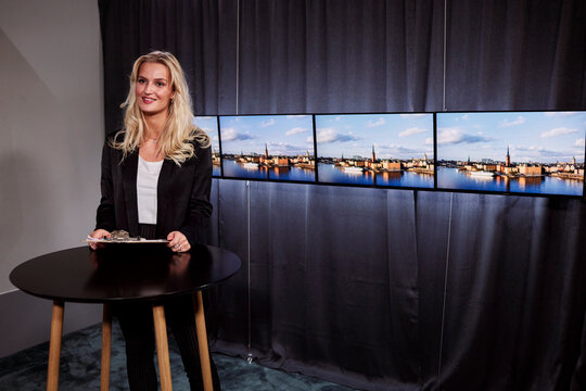 Female News Anchor Reporting News In Studio