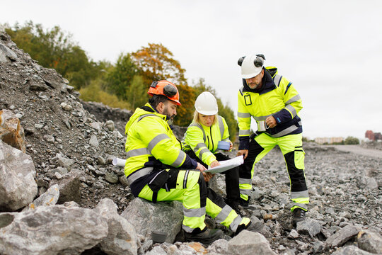 Engineers in reflective clothing looking at plans