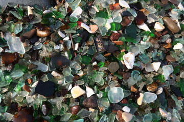 colourful shards of glass polished by sea on a smooth stone, small glass pieces  
