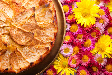 Apple pie in a gold plate on a floral background