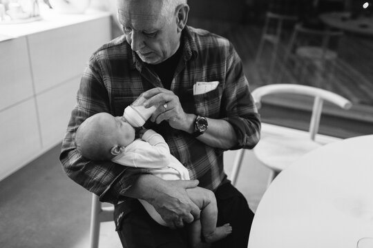 Grandfather feeding grandchild