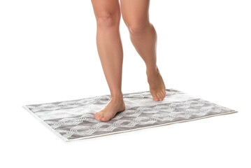 Woman standing on stylish bath mat against white background, closeup