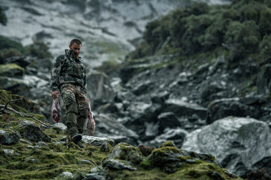 Hunter in mountains carrying meat