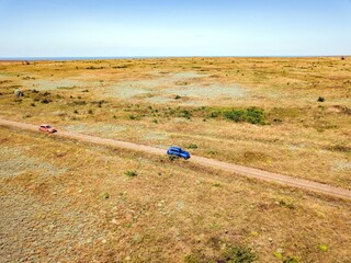 Aerial view of cars go across the field close to Generals' Beaches. Black Sea, Crimea.