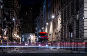 A red double decker in the night on Parliament street in London