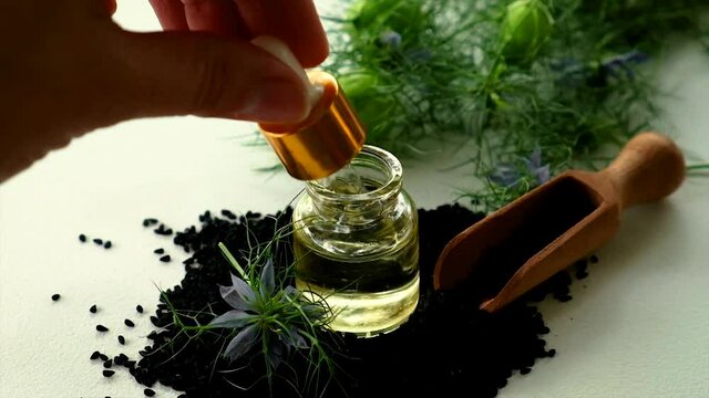 Black cumin oil in a bottle. Selective focus.