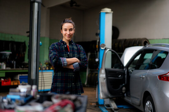 Confident female mechanic standing at workshop