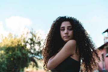 Young south american girl with curly hair looking on camera outdoor - Focus on face