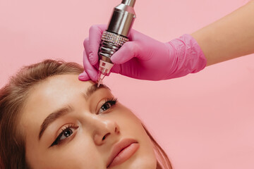 girl getting an eyebrow tattoo