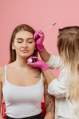 girl draws eyebrows of the model
