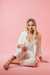 beautiful girl in a white suit on a pink background
