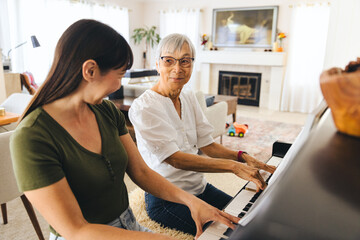 Family Learning Piano Together At Home