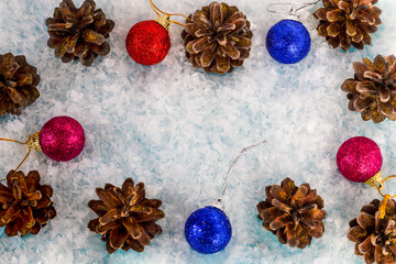 Frame made of snow, cones and Christmas balls