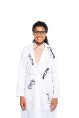 Fototapeta premium Smiling african american oculist in eyeglasses on coat looking at camera isolated on white.