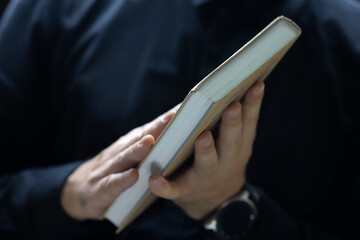 close-up of the end of a book with many pages held by a man