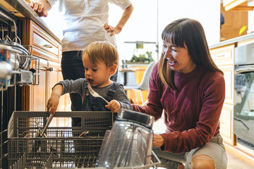 Boy Helping Mother To put Dishes In Dishwasher