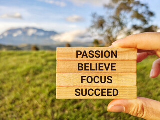 Inspirational and Motivational Concept - PASSION BELIEVE FOCUS SUCCEED text background. Stock photo.