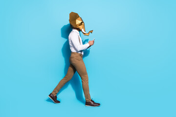 Fototapeta na wymiar Photo of funny wacky man wear elephant mask walking typing modern device isolated blue color background