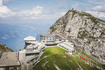 Sunny view on top of Mount Pilatus, overlooking Lucerne lake, with a cogwheel train coming in,...