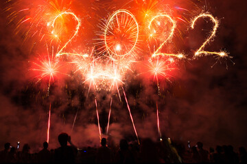 People celebrate new year`s eve and text 2022 of sparklers 2022 and Sparkle firework in the sky.
