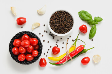 Cherry tomatoes in basket with basil, pepper and garlic.