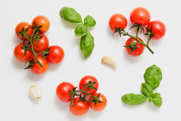 Cherry tomatoes on branches with green basil and garlic.