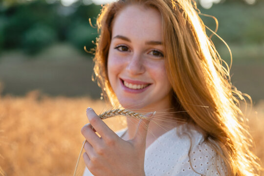 Beautiful Woman Holding Ear Of Wheat Smiling On Sunny Day