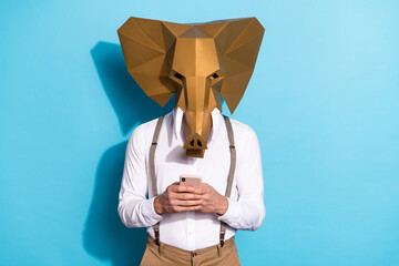 Photo of cool strange guy dressed wild animal mask typing modern device isolated blue color background