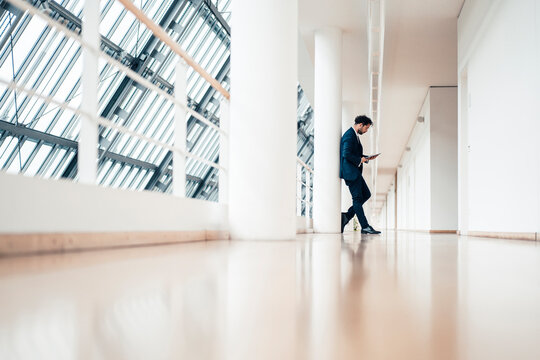 Male entrepreneur using digital tablet while standing in office