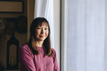 Smiling Woman By Window At Home