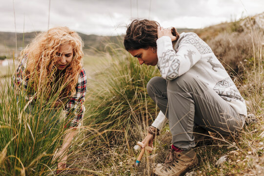 Young and mature women planting on land