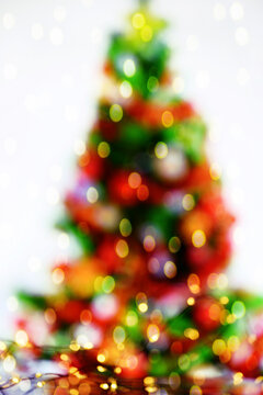 Abstract image of a colorful Christmas tree and lights of garlands on a white background. There is a free space for your labels and ideas.