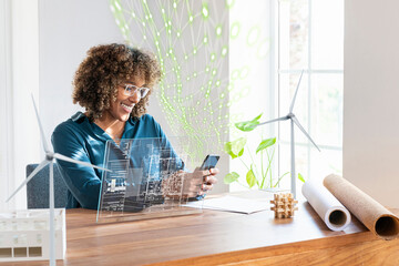 Businesswoman using mobile phone by futuristic device screen and network connection in office