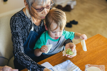 Boy With Grandmother Preparing Dumplings At Home
