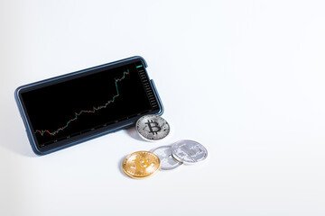 Phone with trand up of bitcoin. Bitcoin phisical money in wjite background