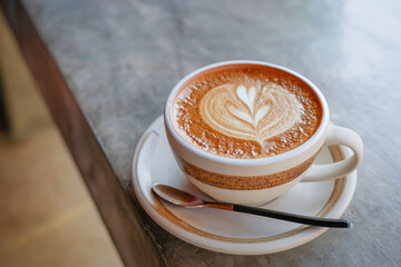 Cappuccino coffee in a beautiful glass on the table favorite cup of coffee concept.
