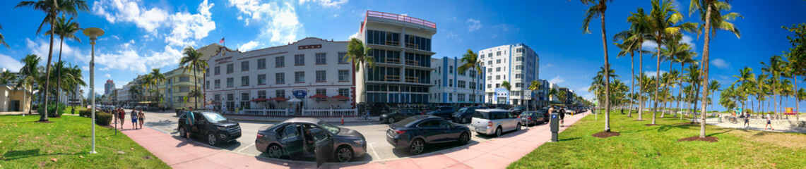 MIAMI BEACH, FL - APRIL 11TH, 2018: Tourists and locals walk along the beautiful city beach promenade near Ocean Drive on a sunny day. - Panoramic view © jovannig